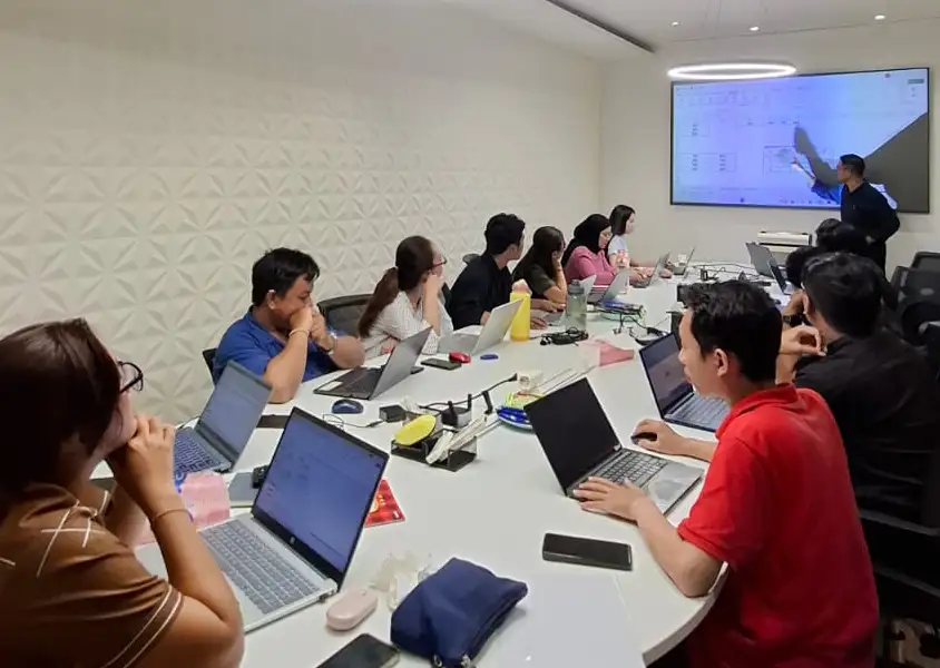Trainer sedang menjelaskan materi Microsoft Excel Intermediate kepada peserta In House Training Kohinoor Group menggunakan layar presentasi interaktif